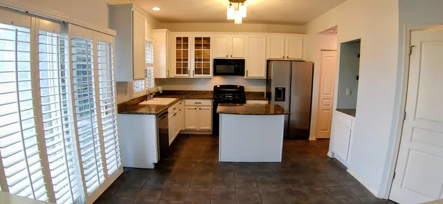 a kitchen with stainless steel appliances a refrigerator a stove a sink and a refrigerator