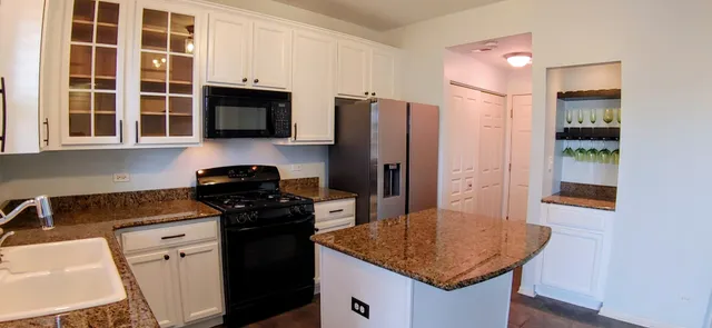 a kitchen with stainless steel appliances granite countertop a stove a refrigerator and a sink