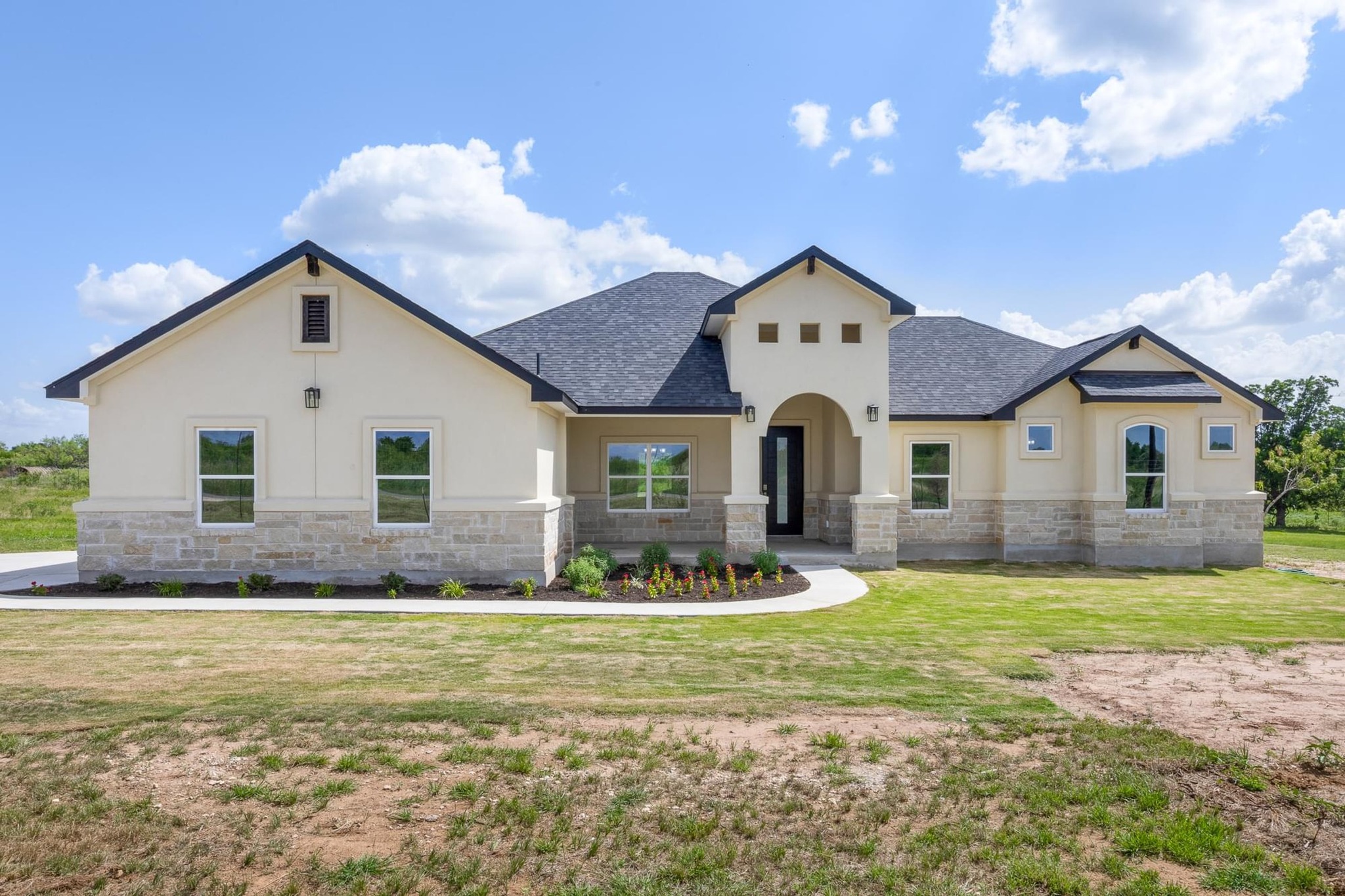 1136 County Road 484 Elgin, TX 78621 - Photo 1 of 37 View of front of home featuring stone siding, stucco siding, a front lawn, and a shingled roof