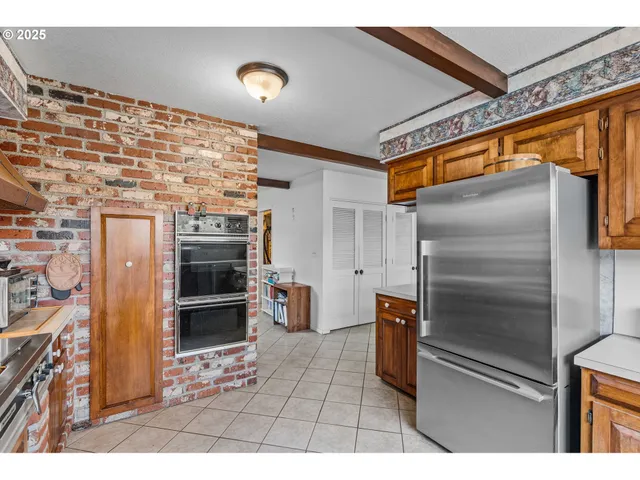 a kitchen with stainless steel appliances kitchen island granite countertop a refrigerator and a stove