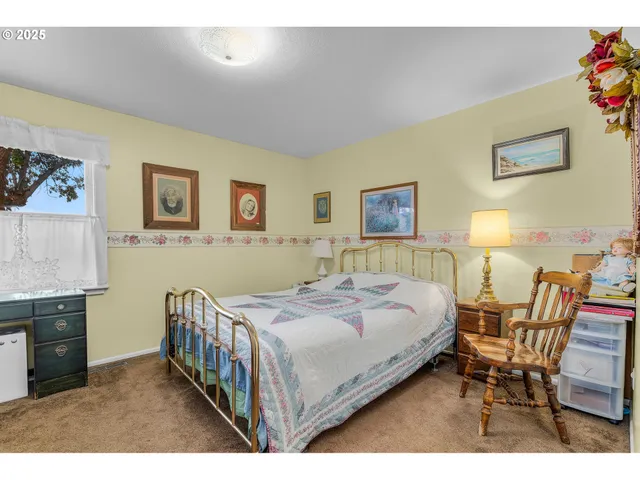 a bedroom with a bed a table and chair