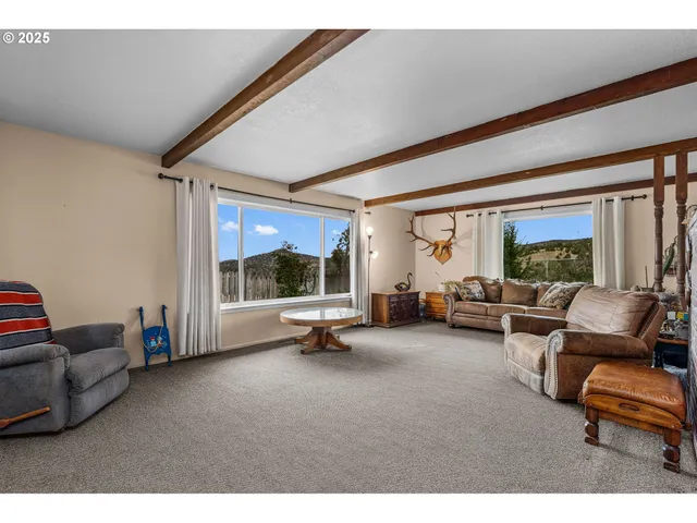 a living room with furniture a flat screen tv and a large window