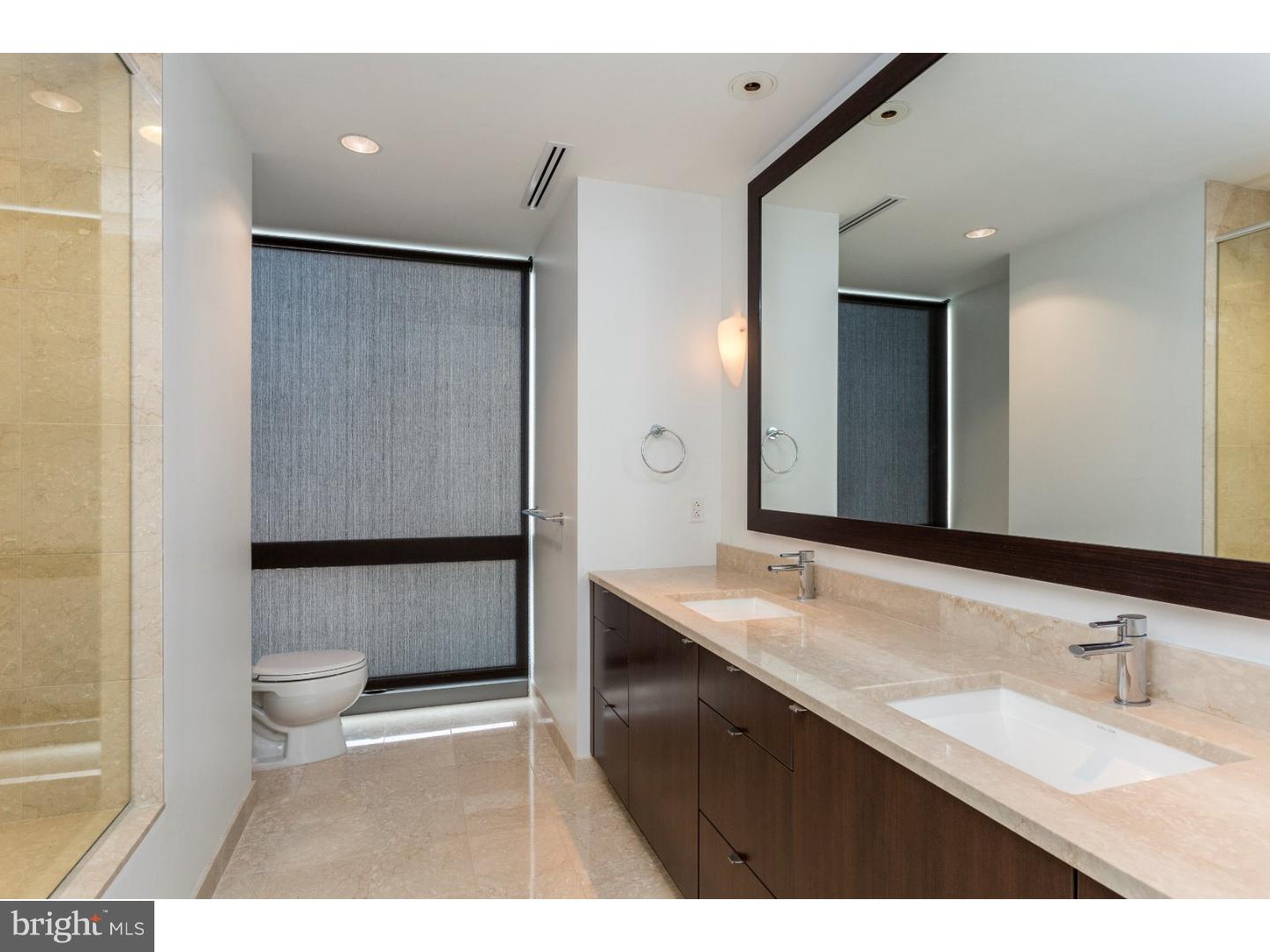 1706 Rittenhouse Square, Unit 402 Philadelphia, PA 19103 - Photo 15 of 17 a bathroom with a sink a toilet and a large mirror