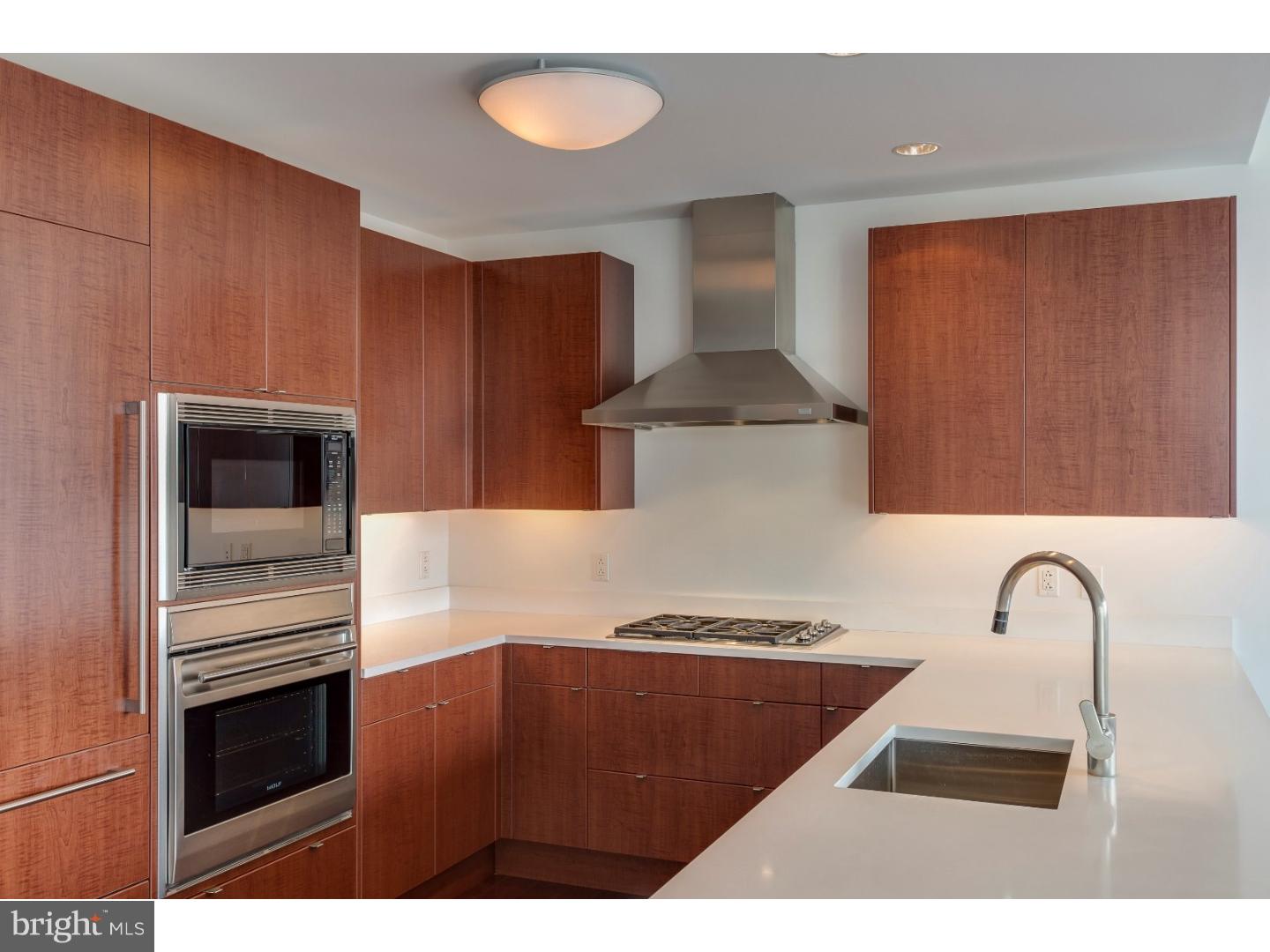 1706 Rittenhouse Square, Unit 402 Philadelphia, PA 19103 - Photo 8 of 17 a kitchen with stainless steel appliances kitchen island a stove a sink and a refrigerator
