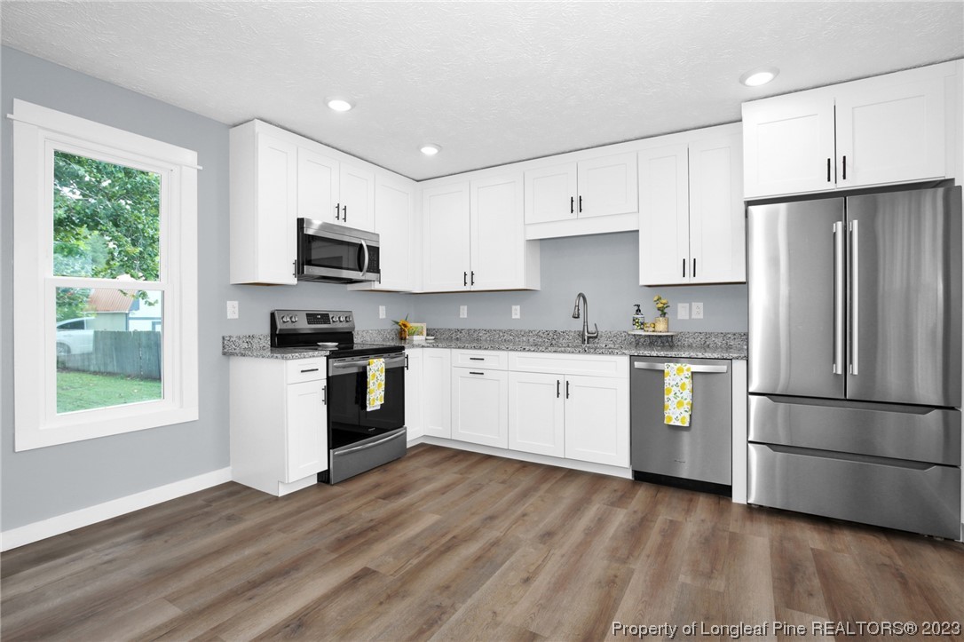 1163 Hoke Loop Road Fayetteville, NC 28314 - Photo 11 of 34 a kitchen with granite countertop a refrigerator stove top oven and sink