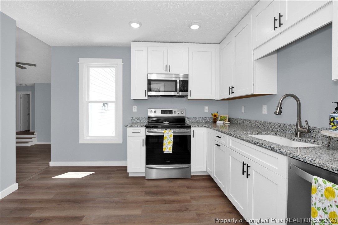 1163 Hoke Loop Road Fayetteville, NC 28314 - Photo 12 of 34 a kitchen with granite countertop a stove a sink and a microwave