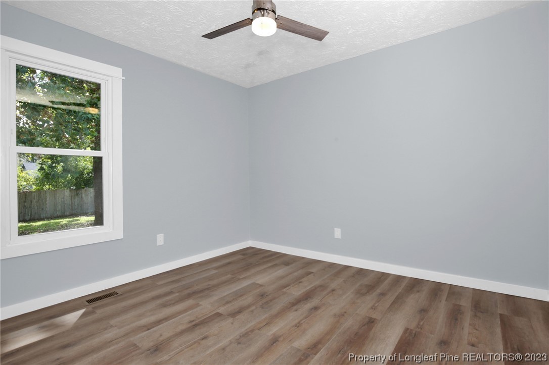 1163 Hoke Loop Road Fayetteville, NC 28314 - Photo 17 of 34 an empty room with a window and wooden floor