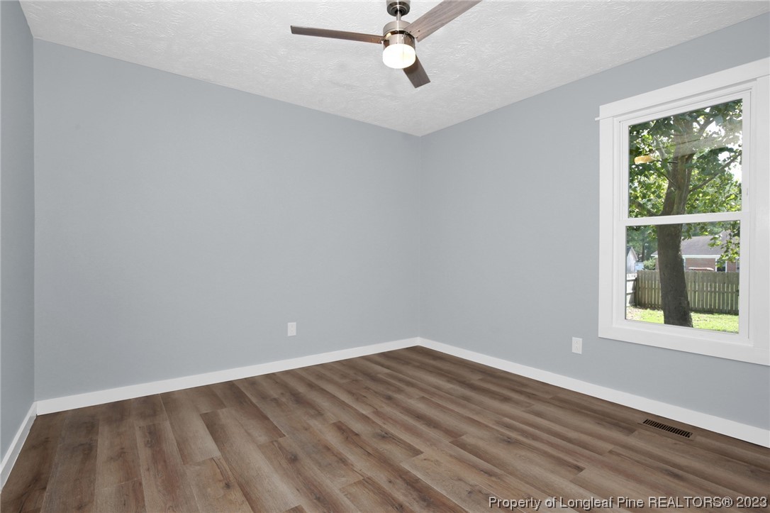 1163 Hoke Loop Road Fayetteville, NC 28314 - Photo 19 of 34 wooden floor in an empty room with a window