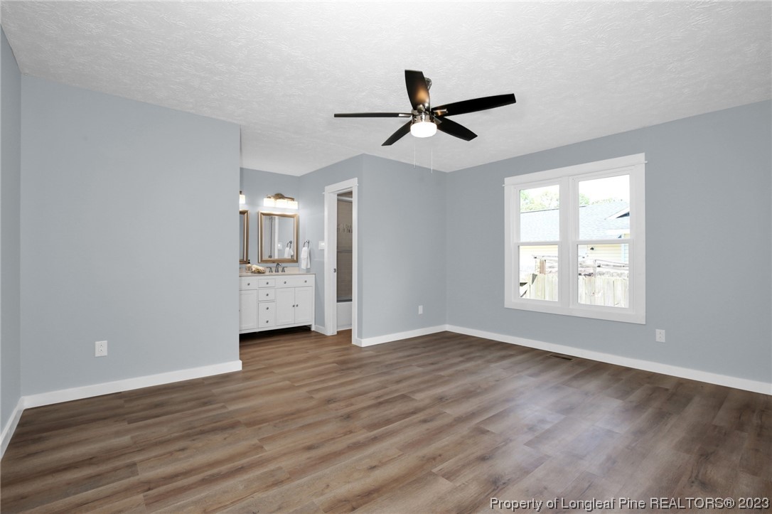 1163 Hoke Loop Road Fayetteville, NC 28314 - Photo 21 of 34 a view of an empty room with wooden floor and a window
