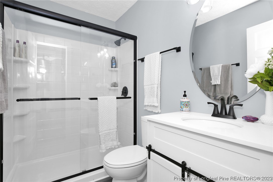 1163 Hoke Loop Road Fayetteville, NC 28314 - Photo 26 of 34 a bathroom with a sink toilet and shower