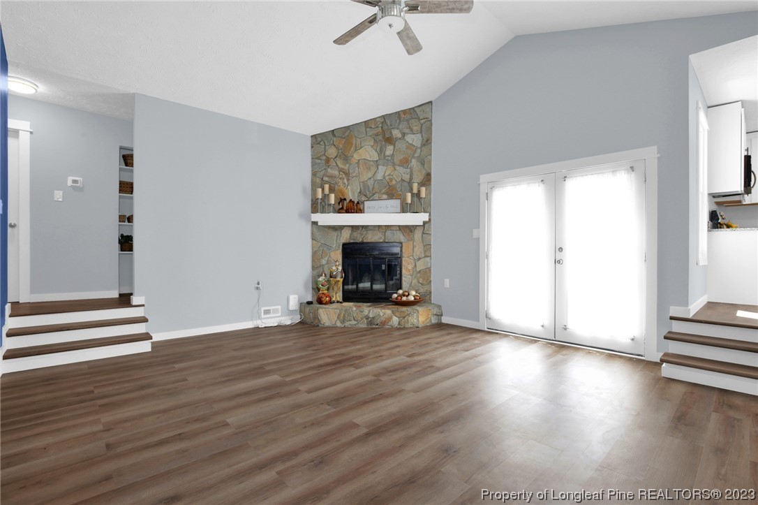1163 Hoke Loop Road Fayetteville, NC 28314 - Photo 8 of 34 an empty room with wooden floor fireplace and windows