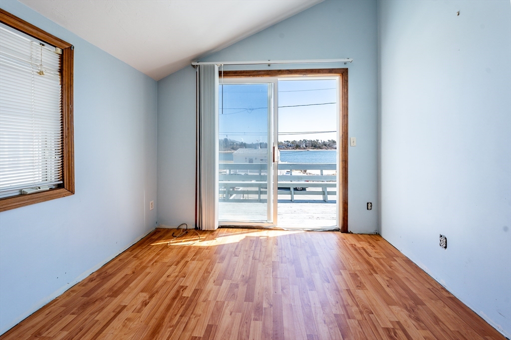 25 Nautical Way, Unit E Bourne, MA 02532 - Photo 7 of 25 a view of an empty room with wooden floor and a window