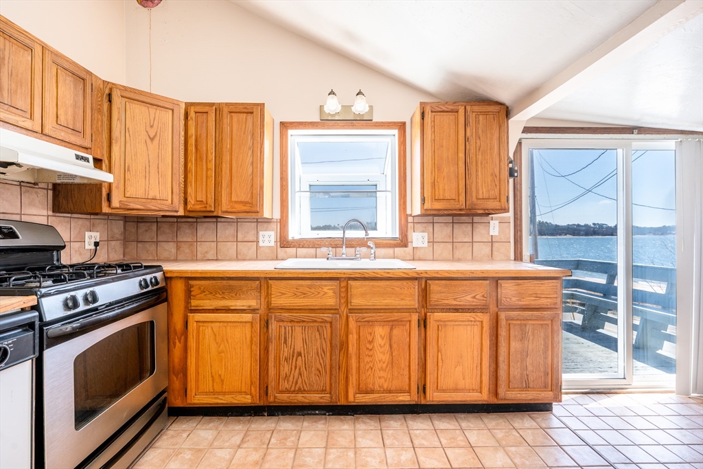 25 Nautical Way, Unit E Bourne, MA 02532 - Photo 8 of 25 a kitchen with granite countertop a sink a stove and cabinets