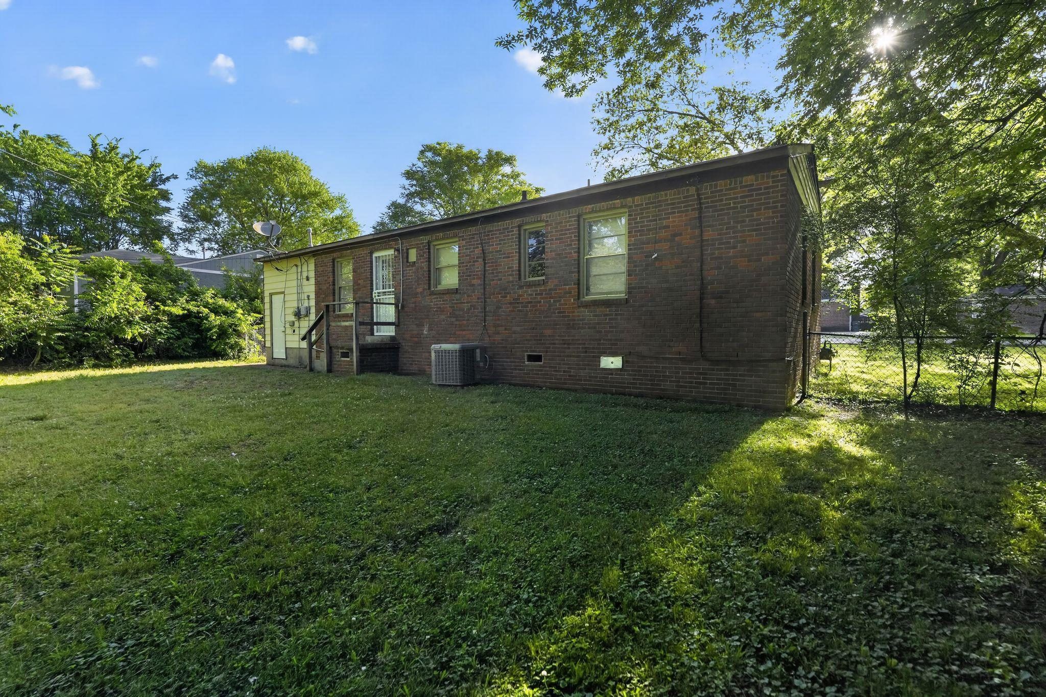 4955 Stacey Road Memphis, TN 38109 - Photo 7 of 35 Rear exterior featuring brick siding, a light-colored entry door, and an air conditioning unit