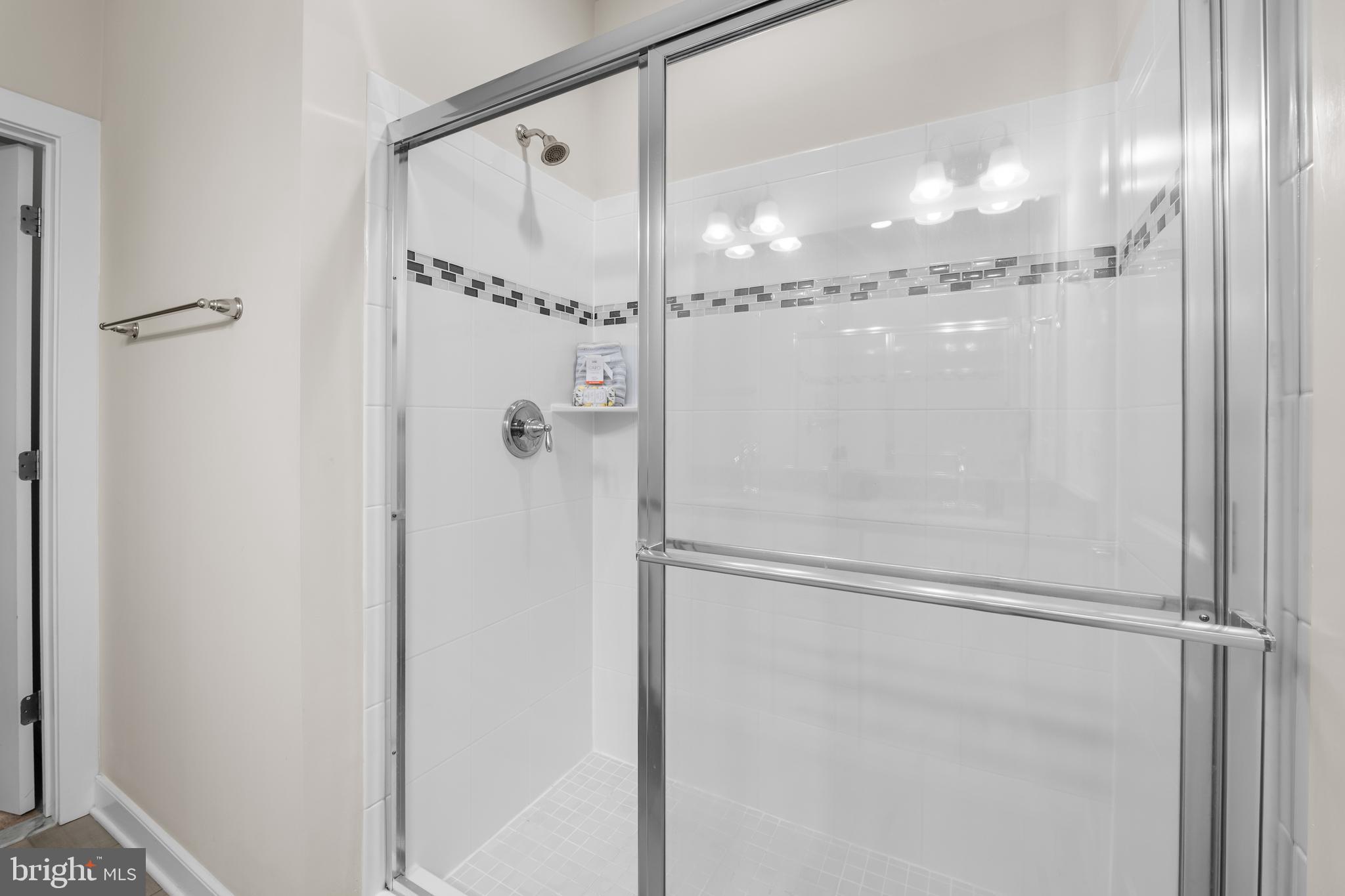 9780 Fields Road Gaithersburg, MD 20878 - Photo 18 of 37 a bathroom with a glass shower door