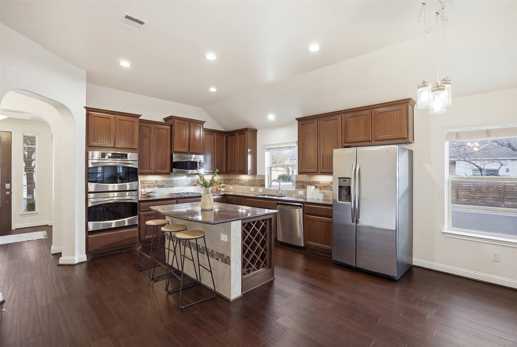 13600 Hymeadow Circle Austin, TX 78729 - Photo 5 of 34 a kitchen with stainless steel appliances granite countertop a refrigerator a stove top oven a sink and dishwasher with wooden floor