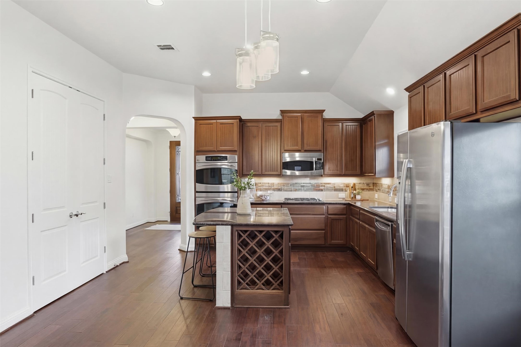 13600 Hymeadow Circle Austin, TX 78729 - Photo 7 of 34 a kitchen with kitchen island granite countertop a refrigerator stove top oven and sink