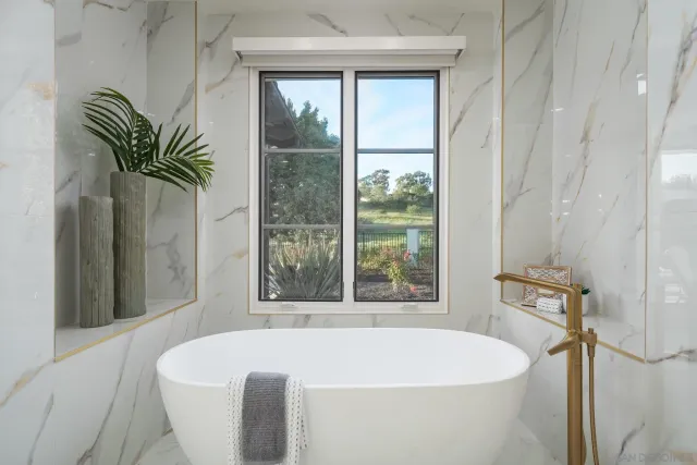 a bath tub sitting in a bathroom next to a window