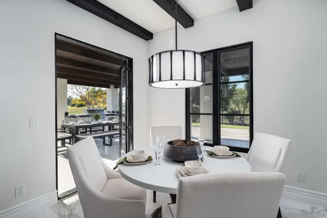 a dining room with furniture a chandelier and wooden floor