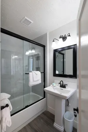a bathroom with a sink mirror and shower