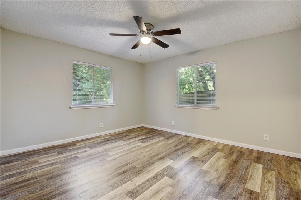2311 Teri Road, Unit B Austin, TX 78744 - Photo 11 of 25 a view of an empty room with wooden floor and a window