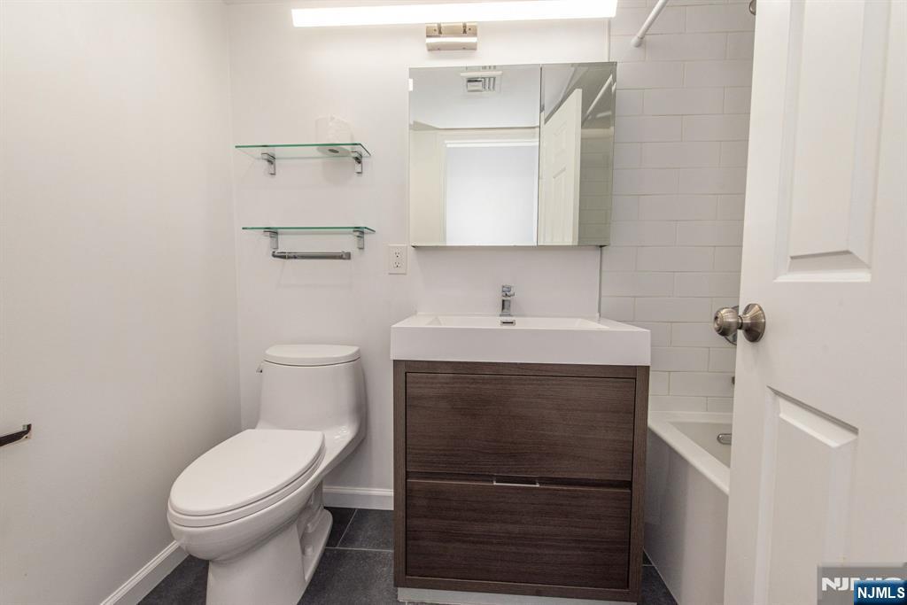 69 Amethyst Lane, Unit 283 Paterson, NJ 07501 - Photo 11 of 20 a bathroom with a sink a toilet and mirror