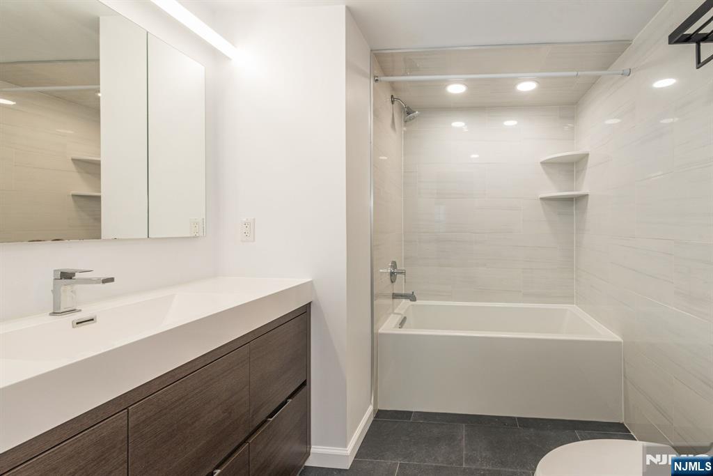 69 Amethyst Lane, Unit 283 Paterson, NJ 07501 - Photo 16 of 20 a bathroom with a bathtub shower sink vanity and toilet