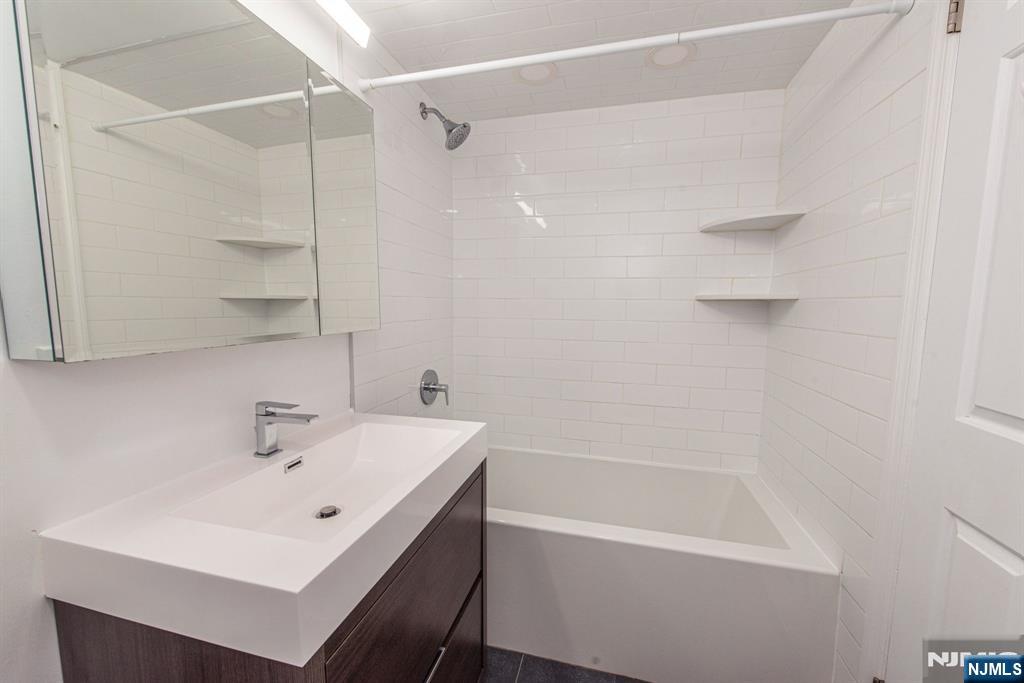 69 Amethyst Lane, Unit 283 Paterson, NJ 07501 - Photo 10 of 20 a white bath tub sitting next to a white sink and a shower