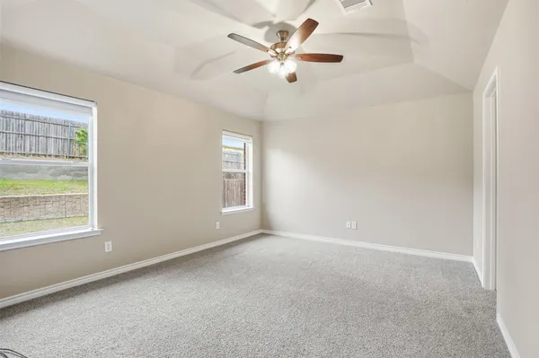 an empty room with a window and a fan
