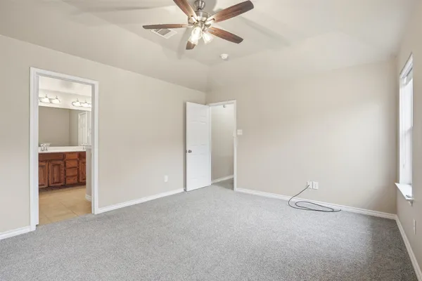 a view of an empty room and a ceiling fan