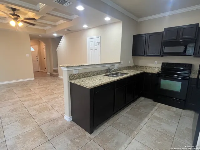 a kitchen with stainless steel appliances granite countertop a stove a sink and a microwave