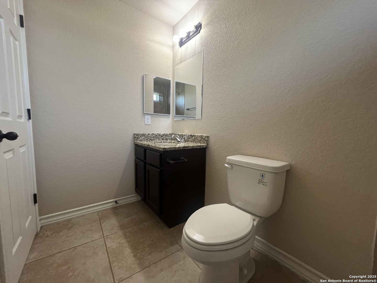 16824 Dancing Ava, Unit 1 Selma, TX 78154 - Photo 18 of 26 a bathroom with a granite countertop toilet and a sink