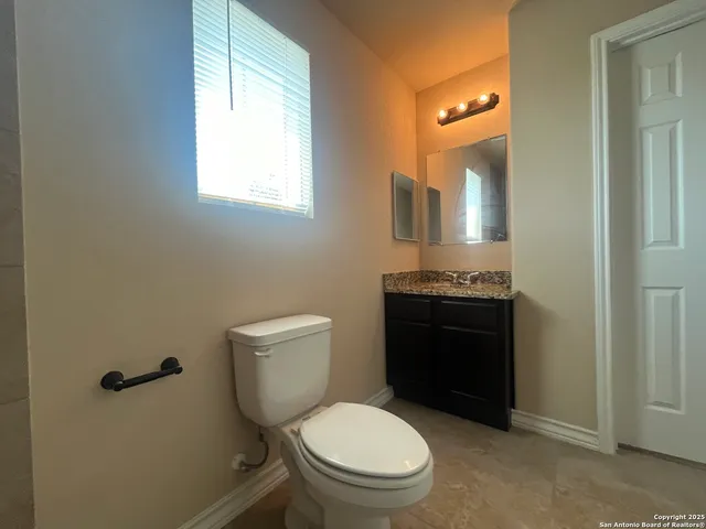 a bathroom with a granite countertop toilet a mirror and a sink