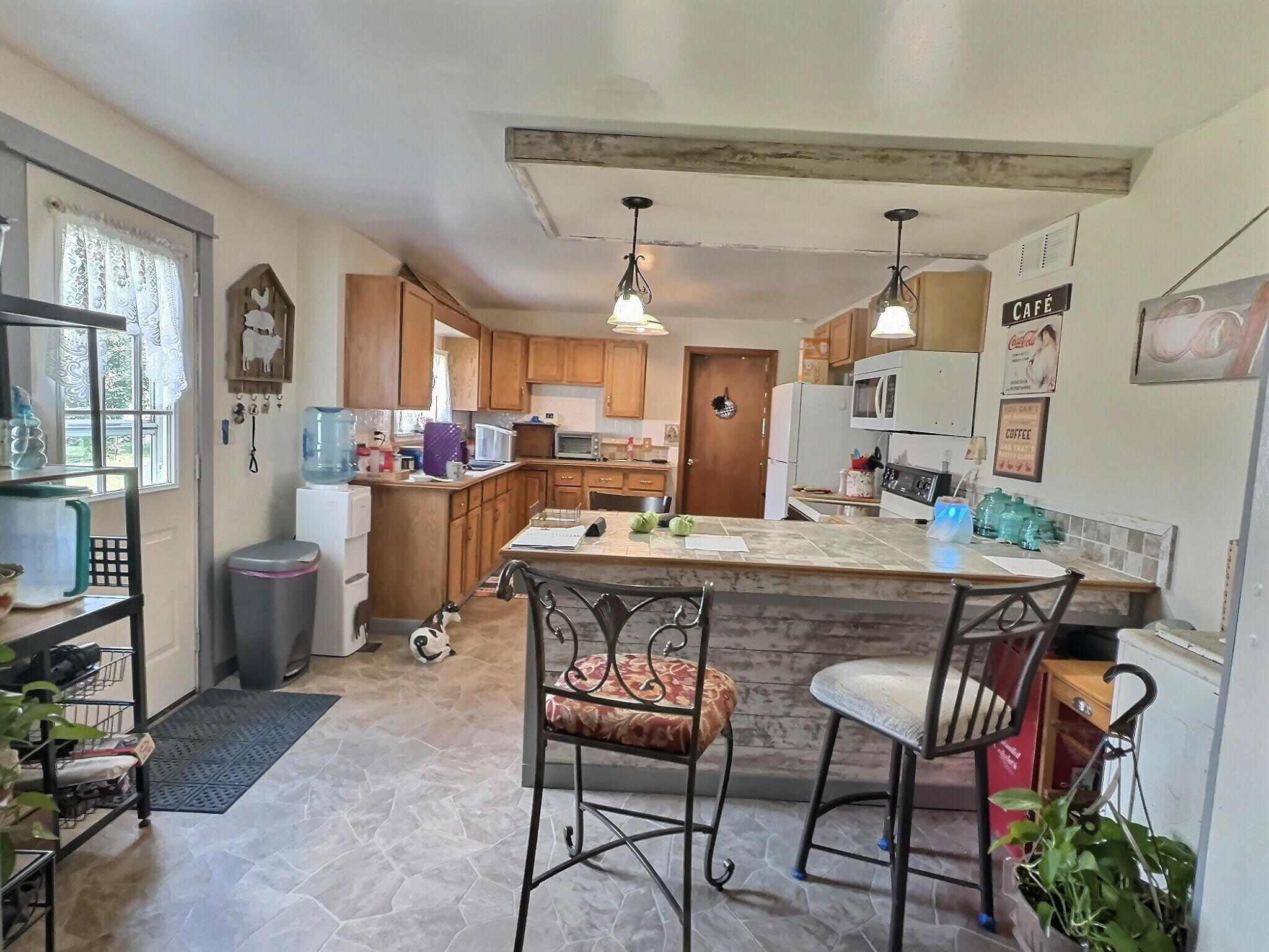 103 West Goss Street Kentland, IN 47951 - Photo 16 of 26 a dining hall with stainless steel appliances kitchen island granite countertop a dining table and chairs