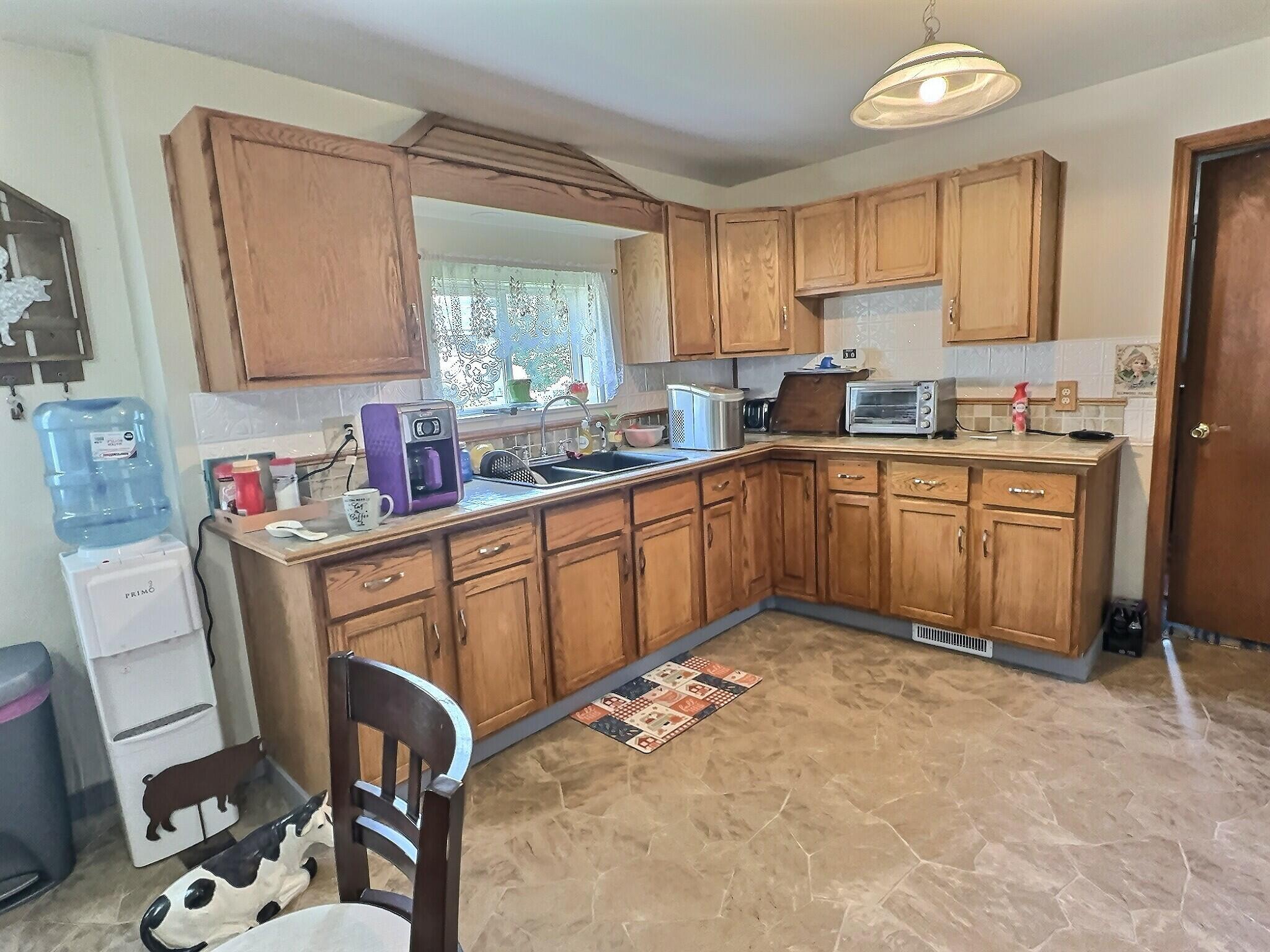 103 West Goss Street Kentland, IN 47951 - Photo 17 of 26 a kitchen with a sink cabinets and window
