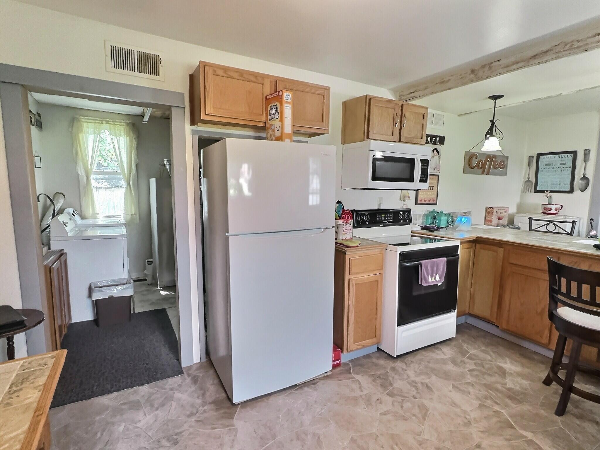 103 West Goss Street Kentland, IN 47951 - Photo 18 of 26 a kitchen with stainless steel appliances kitchen island granite countertop a refrigerator stove top oven and sink
