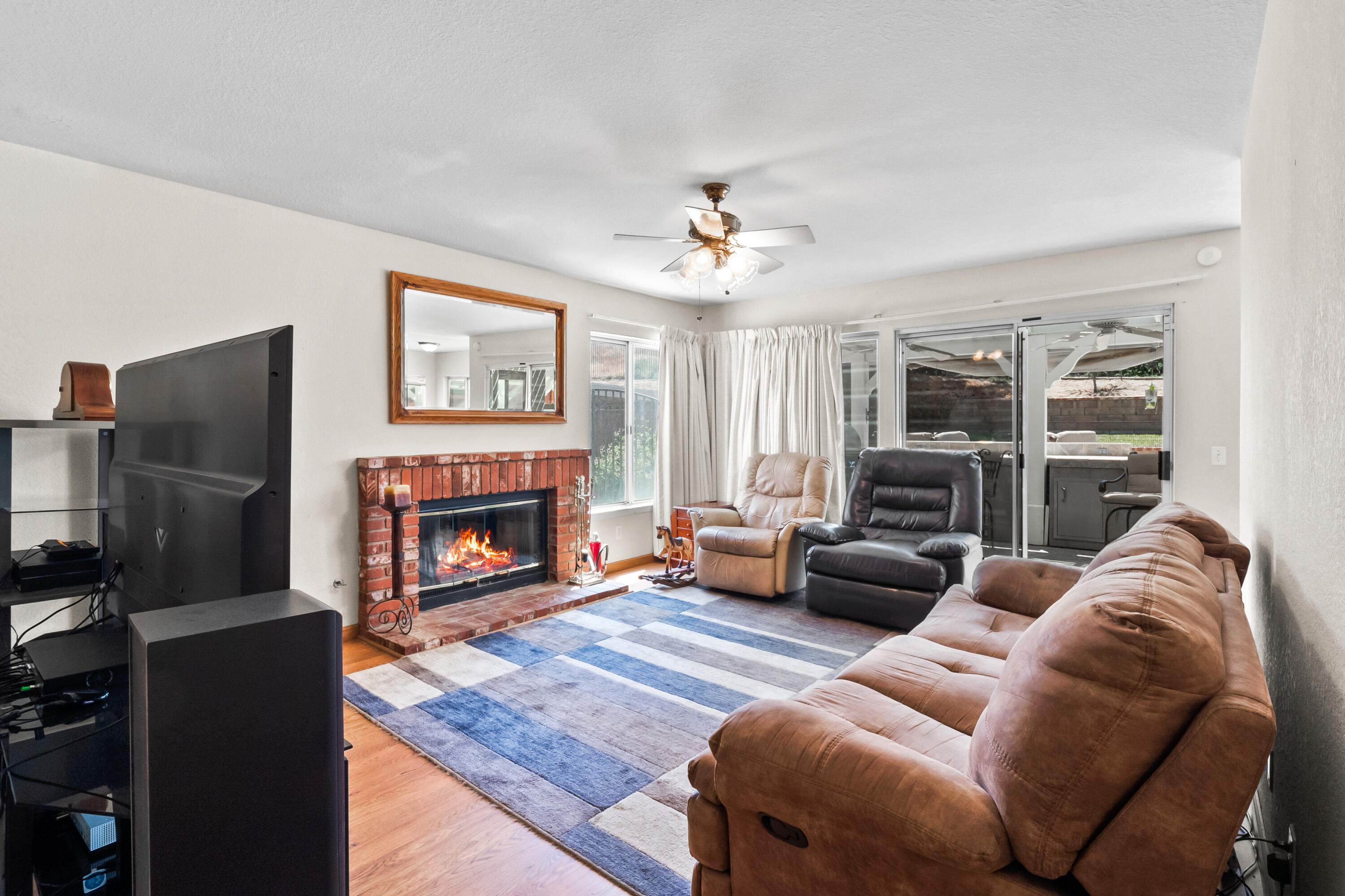 3066 Quarry Road Palmdale, CA 93550 - Photo 11 of 43 a living room with furniture a fireplace and a flat screen tv