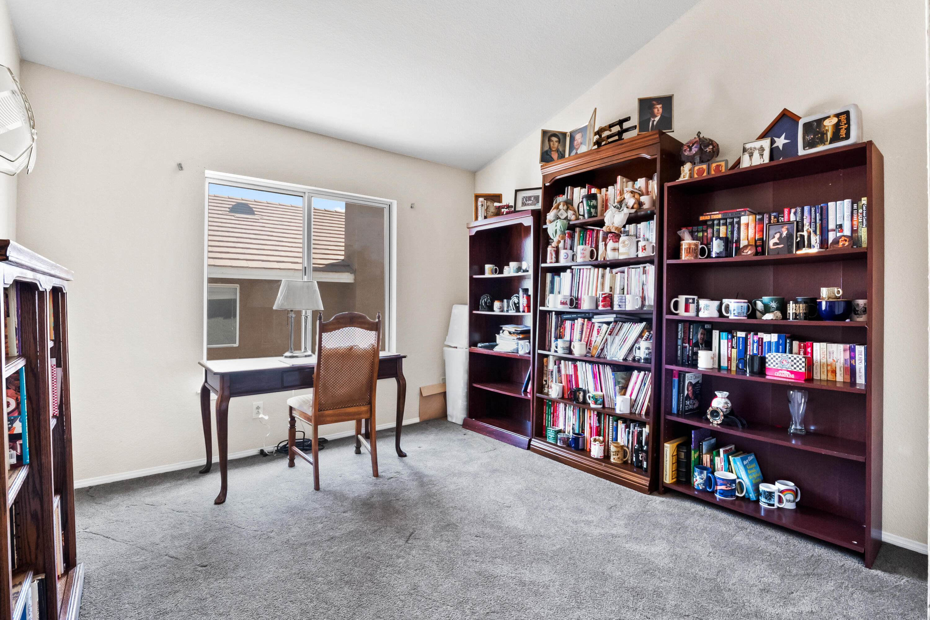 3066 Quarry Road Palmdale, CA 93550 - Photo 28 of 43 a living room with lots of furniture and a book shelf