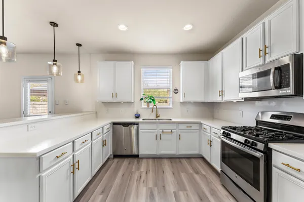 a kitchen with a refrigerator a sink and a stove top oven