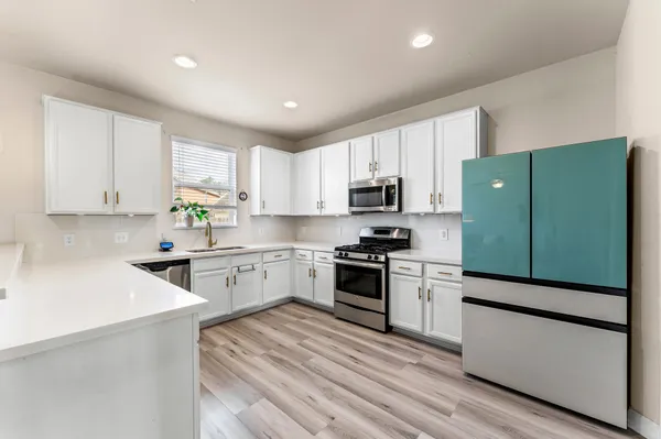 a kitchen with stainless steel appliances kitchen island hardwood floor sink and stove