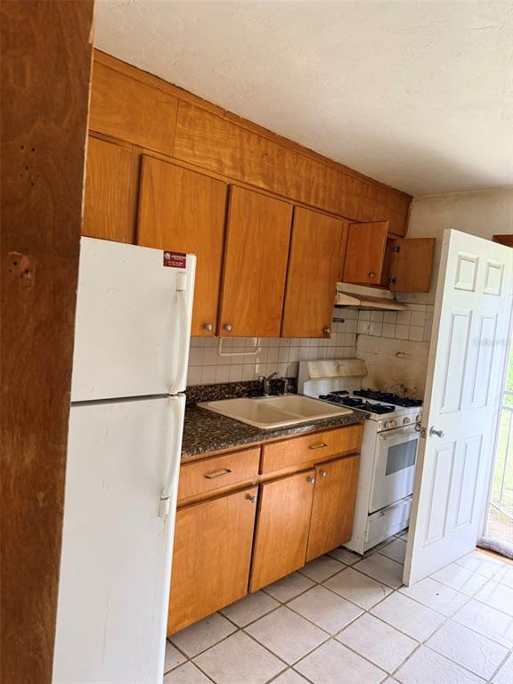 2114 Southwest 7th Street Ocala, FL 34471 - Photo 4 of 10 a kitchen with a stove a refrigerator and a sink