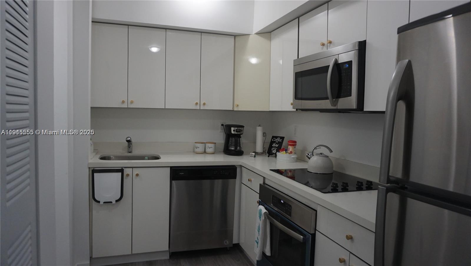810 7th Street, Unit 107 Miami Beach, FL 33139 - Photo 5 of 14 a kitchen with stainless steel appliances granite countertop a refrigerator sink and microwave