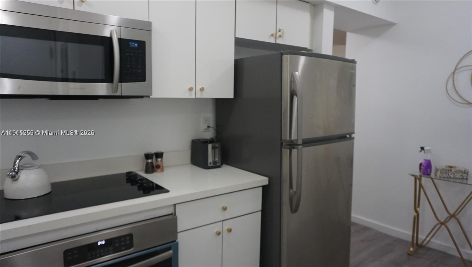 810 7th Street, Unit 107 Miami Beach, FL 33139 - Photo 6 of 14 a kitchen with a refrigerator and cabinets