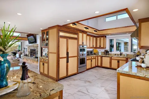 a kitchen with stainless steel appliances granite countertop a refrigerator and a stove top oven
