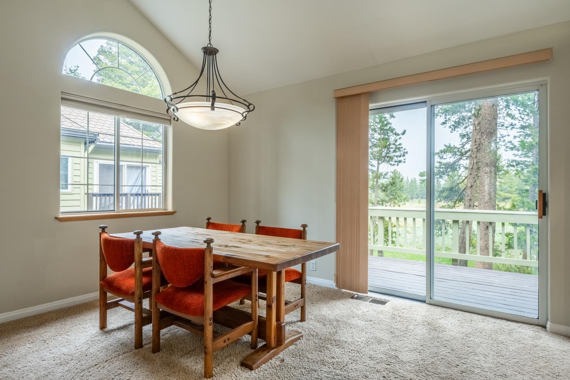 272 Ridge Way Mammoth Lakes, CA 93546 - Photo 15 of 55 Vaulted ceiling room featuring a large arched window, a glass sliding door, and neutral-toned carpeting