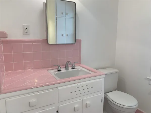 a bathroom with a sink a toilet and mirror