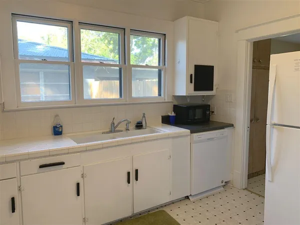 a kitchen with a sink cabinets and a window