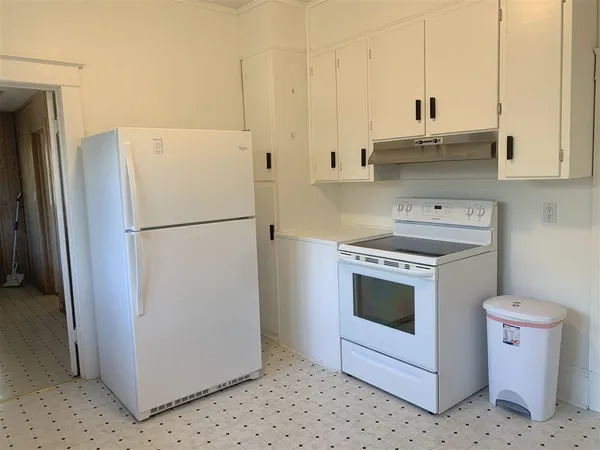 a kitchen with a refrigerator sink stove and cabinets