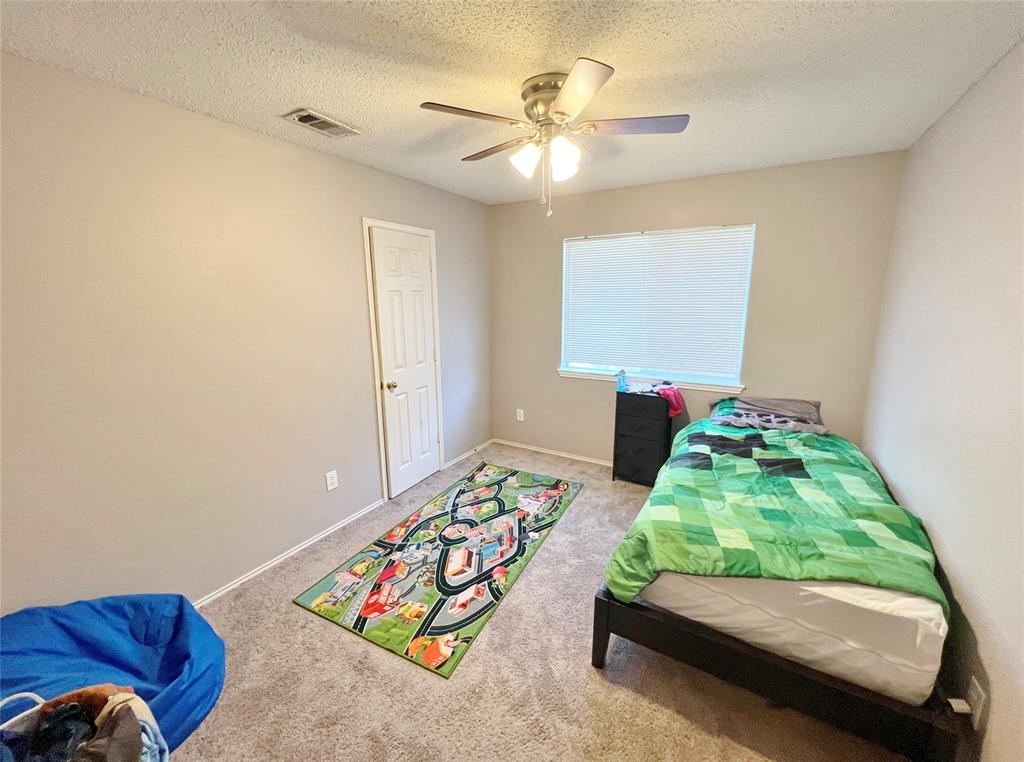 112 Walnut Lane Rockwall, TX 75032 - Photo 13 of 19 a bedroom with bed and a couch