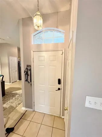 a view of a hallway with wooden floor and a chandelier
